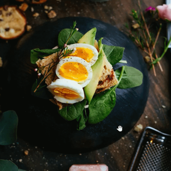 A plate of spinach with toast, avocado and eggs
                    present as art.